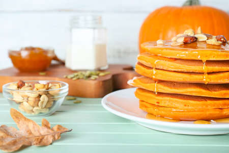 Tasty pumpkin pancakes on tableの写真素材
