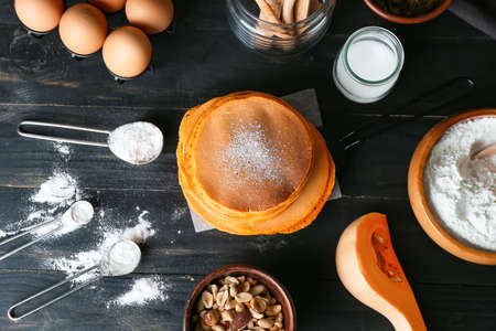 Tasty pumpkin pancakes with ingredients on tableの写真素材