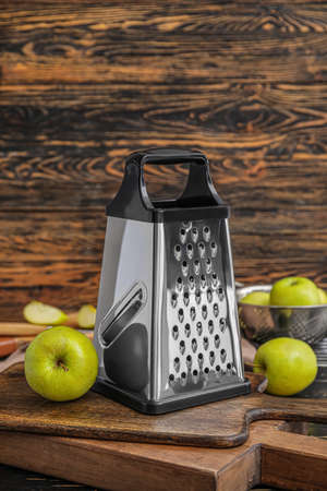 Metal grater and apples on wooden backgroundの写真素材