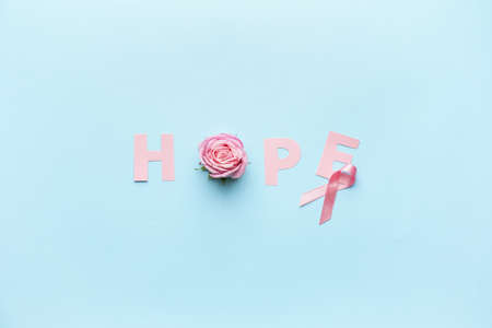 Pink ribbon, word HOPE and rose on color background. Breast cancer awareness conceptの写真素材