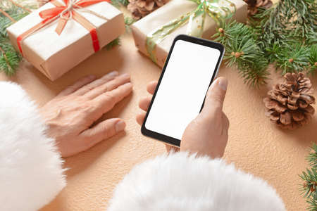 Santa Claus with mobile phone at table