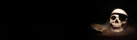 Pirate skull and treasure on dark background with space for text