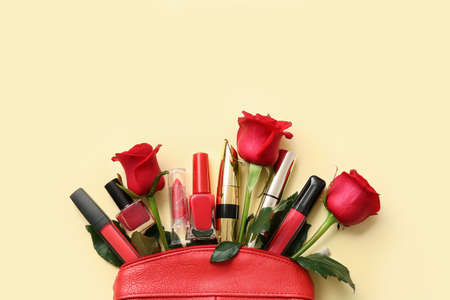 Beautiful red roses and cosmetics on color backgroundの写真素材