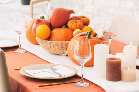Beautiful table setting with pumpkins in dining room