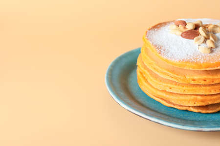 Plate with tasty pumpkin pancakes on color backgroundの写真素材