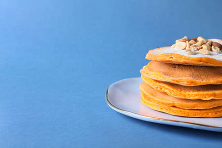 Plate with tasty pumpkin pancakes on color backgroundの写真素材