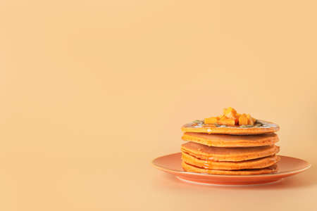 Plate with tasty pumpkin pancakes on color backgroundの写真素材