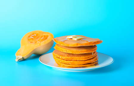 Plate with tasty pumpkin pancakes on color backgroundの写真素材