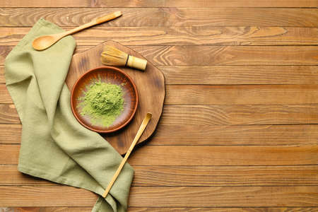 Composition with powdered matcha tea on wooden background