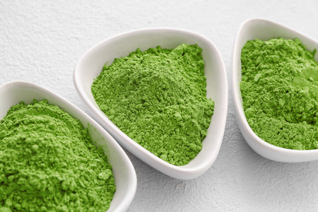 Bowls with powdered matcha tea on light backgroundの写真素材