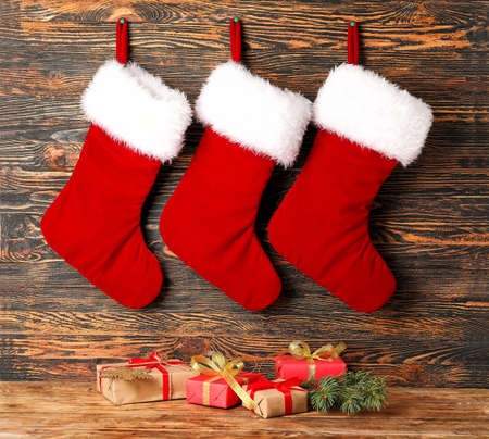 Christmas socks with gifts on wooden background