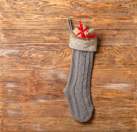 Christmas sock with gifts on wooden backgroundの写真素材