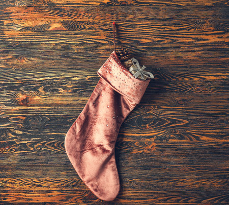 Christmas sock with gifts on wooden backgroundの写真素材