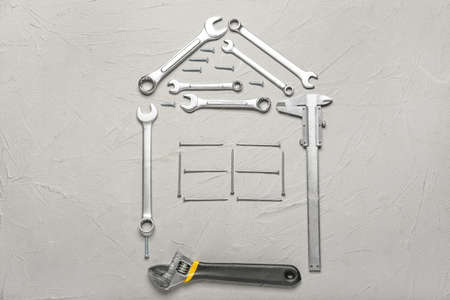 Composition with model of house and construction tools on light backgroundの写真素材