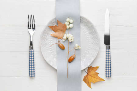 Beautiful table setting with autumn decor on white wooden background