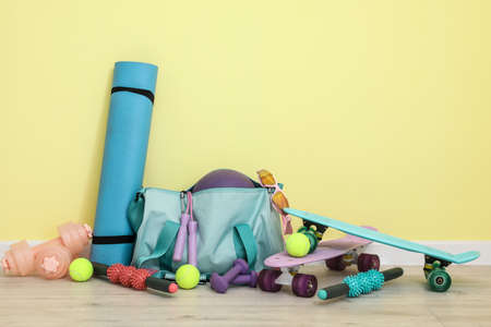 Set of sport equipment on floor near color wallの写真素材