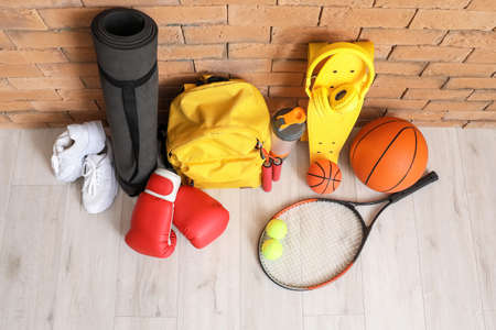 Set of sport equipment on floor near brick wall