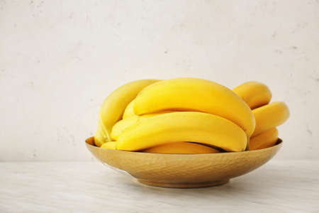 Bowl with ripe bananas on light backgroundの写真素材