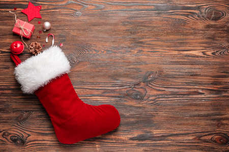 Composition with Christmas sock on wooden background