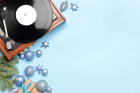 Record player and Christmas decor on color background