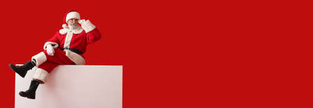 Santa Claus with blank poster on color background with space for textの写真素材