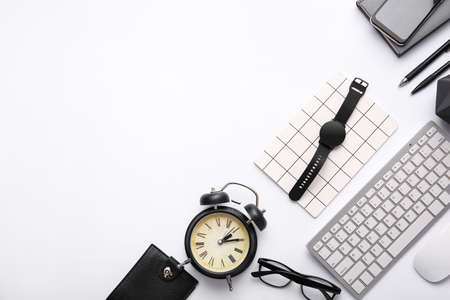 Composition with modern smart watch, computer keyboard and alarm clock on light backgroundの写真素材