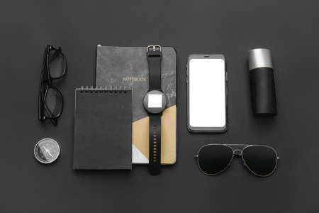 Composition with modern smart watch, mobile phone and notebooks on dark backgroundの写真素材