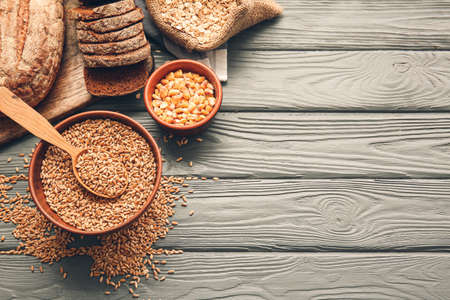 Different cereals and bread on wooden backgroundの写真素材