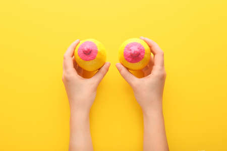 Female hands with painted lemons on color background. Erotic conceptの写真素材