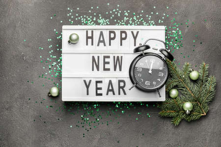 New Year composition with alarm clock on dark background