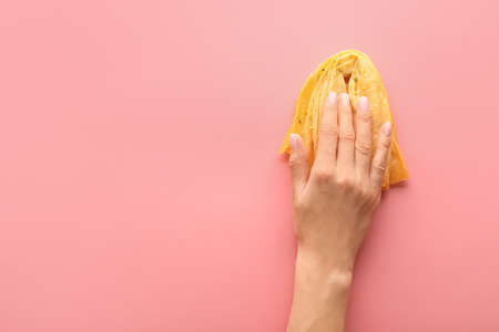 Female hand with sweet Eastern treat on color background. Erotic concept