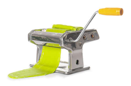 Pasta machine with dough on white background