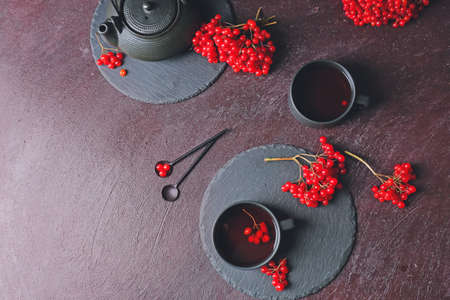 Cups of healthy viburnum tea on dark backgroundの写真素材