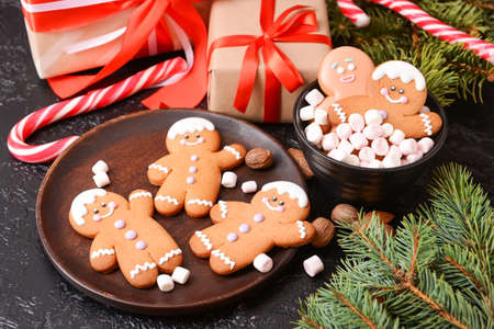 Christmas composition with gingerbread cookies and gifts on dark background