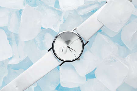 Wrist watch with ice cubes on color backgroundの写真素材