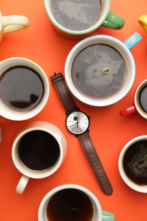 Wrist watch with coffee cups on color background