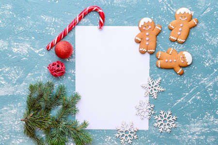 Christmas composition with gingerbread cookies and empty paper sheet on color backgroundの写真素材