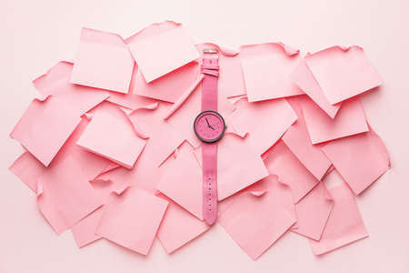 Wrist watch with paper sheets on color backgroundの写真素材
