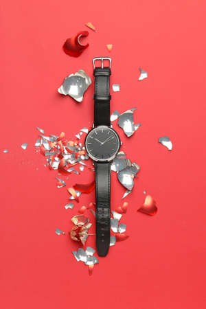 Wrist watch with crashed Christmas ball on color backgroundの写真素材