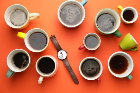 Wrist watch with coffee cups on color backgroundの写真素材