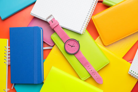 Wrist watch with notebooks on color background backgroundの写真素材