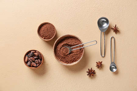 Bowls with cacao powder and beans on color backgroundの写真素材