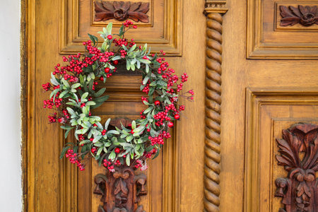Beautiful Christmas wreath hanging on doorの写真素材