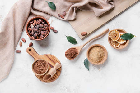 Cacao powder with beans and sugar on light backgroundの写真素材