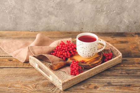 Tray with cup of healthy viburnum tea on tableの写真素材