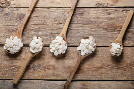 Spoons with chocolate drops on wooden backgroundの写真素材