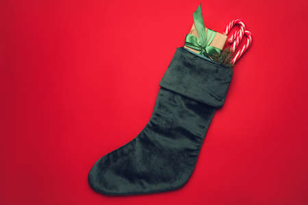 Christmas sock with gifts on color backgroundの写真素材