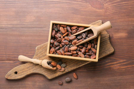 Box with cacao beans on wooden backgroundの写真素材