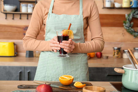 Woman making tasty mulled wine at homeの写真素材