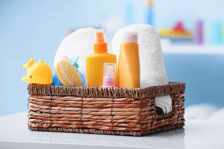 Basket with bath accessories for baby on table in bathroom